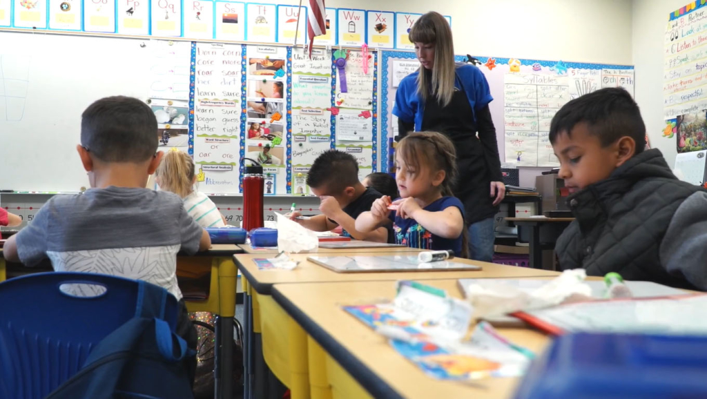Children in classroom writing on whiteboards