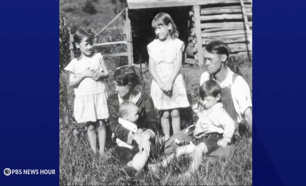 Credit: PBS News Hour screenshot of a black and white photo of Dolly Parton as a young child with her family