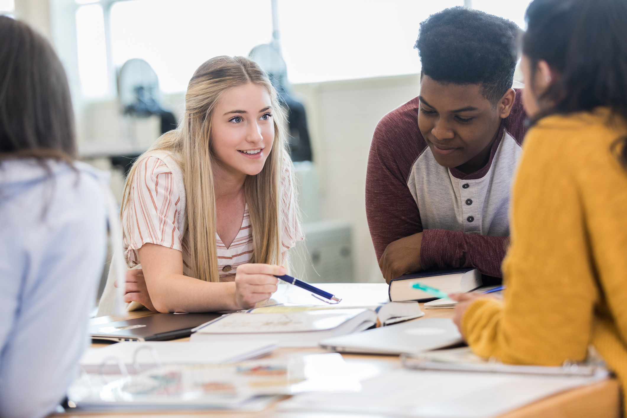 Teen girl uses pen to point out answer in text stock photo