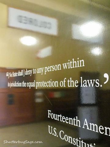 14th Amendment sign at the entrance of the Brown v Board of Education Historical Site in Topeka, KS. The "Colored" and "White" signs are reflected in the sign.